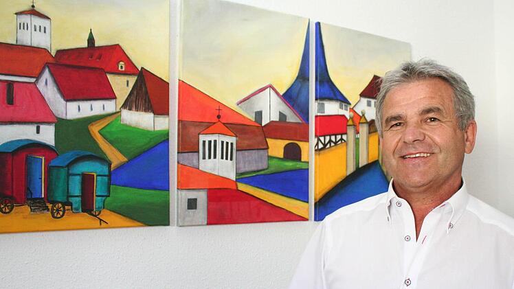 Bürgermeister Ludwig Nagel vor den Bildern im Rathaus, die Hemhofener Motive zeigen. Foto: Evi Seeger