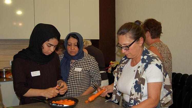 Möhren für Ghormeh Sabzi werden teilweise geraspelt und teilweise geschnitten. v. l. Zeinab Karimi, Sima Abasi und Andrea Schiele-Eberlein.