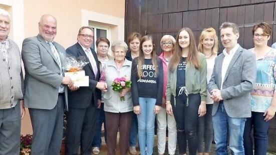 Louise Regel (mit Blumen) mit (von links) Schwiegersohn Rudi Fechner, Bürgermeister Ralf Holzmann, stellvertretendem Landrat Dieter Schaar, Tochter Gretel Fechner, Tochter Astrid Mahr, Urenkelin Amelie Fechner, Stanka Stübinger, Urenkelin Vanessa Fechner, Tanja Fechner, Pfarrer Matthias Rückert, Enkelin Iris Friedlein-Feulner und Enkel Klaus Fechner.  Foto: Klaus-Peter Wulf