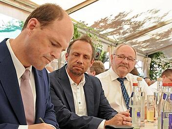 Umweltminister Thorsten Glauber (M.) und stellvertretender Landrat Otto Siebenhaar beobachten aufmerksam, was Michael Hofmann ins Goldene Buch schreibt.  Foto: Karl Heinz Wirth
