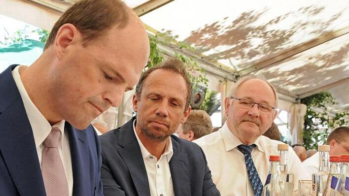Umweltminister Thorsten Glauber (M.) und stellvertretender Landrat Otto Siebenhaar beobachten aufmerksam, was Michael Hofmann ins Goldene Buch schreibt.  Foto: Karl Heinz Wirth