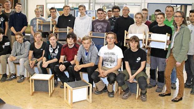 Fast 30 Kinderstühle für den Kindergarten Sankt Martin Sand haben die Auszubildenden im Berufsgrundschuljahr Holz an der Heinrich-Thein-Berufsschule Haßfurt angefertigt und damit gezeigt, was sie in ihrem ersten Ausbildungsjahr gelernt haben. Aus den Händen von Fachoberlehrer Stefan Klauer (Dritter von rechts) nahm die Kindergartenleiterin Marion Mühlfelder (Zweite von rechts) die Stühle entgegen.  Foto: Sabine Weinbeer