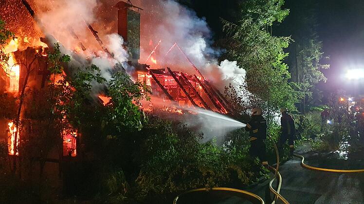 Gebäude in Flammen, Feuerwehrkräfte bei Löscharbeiten