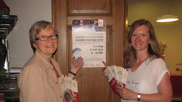 Christine Spiller (rechts) und Brigitte Maisch (links) rühren die Werbetrommel für das Doppeljubiläum von Stadtbücherei und Puppenmuseum am Samstag, 8. Juli. Foto: Martin Koch