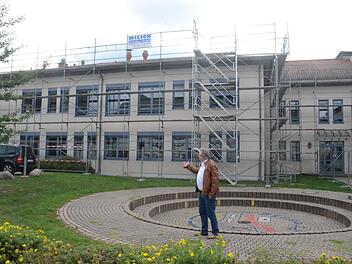 Bürgermeister Hans Pietz weist auf die Baustelle des Dachausbaus der Mittelschule Pressig hin. Es wird mehr Platz für die Schüler geschaffen. Im Bauausschuss wurden weitere Themen besprochen. Eine Diskussion entfachte, als es um Friedhöfe ging. Foto: Karl-Heinz Hofmann
