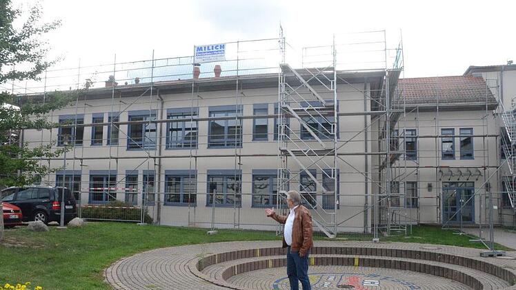 Bürgermeister Hans Pietz weist auf die Baustelle des Dachausbaus der Mittelschule Pressig hin. Es wird mehr Platz für die Schüler geschaffen. Im Bauausschuss wurden weitere Themen besprochen. Eine Diskussion entfachte, als es um Friedhöfe ging. Foto: Karl-Heinz Hofmann