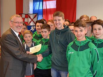 Bürgermeister Waldemar Bug überreicht Torschützenkönig Julius Albert die Auszeichnung - stellvertretend für die erfolgreichen Fußballer der U15-Mannschaft der SG DJK Stralsbach. Foto: Foto: Kathrin Kupka-Hahn