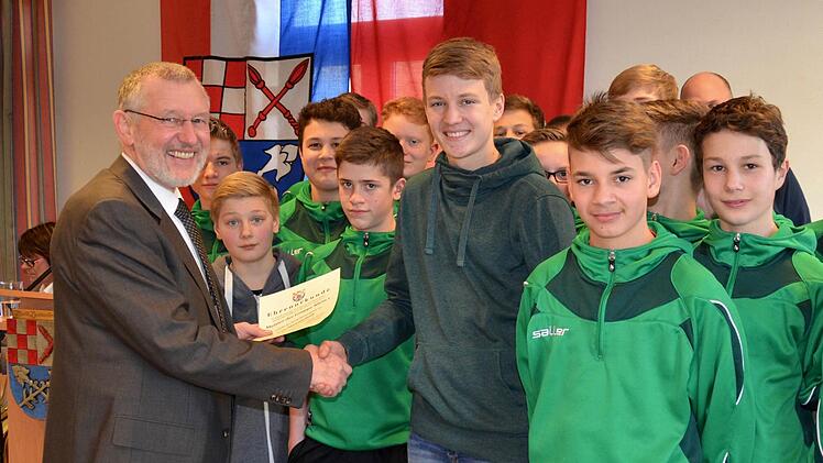 Bürgermeister Waldemar Bug überreicht Torschützenkönig Julius Albert die Auszeichnung - stellvertretend für die erfolgreichen Fußballer der U15-Mannschaft der SG DJK Stralsbach. Foto: Foto: Kathrin Kupka-Hahn