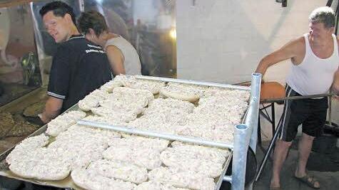 Ein Blech mit 38 Winzerbrötchen liegt zum Backen bereit. "Chefbäcker" Erhard Virnekäs (rechts) und das Backteam hatten einen wahrlich heißen Arbeitsplatz. Aus neun Blechen besteht derweil ein Schuss. Die Helfer hatten beim Weinfest der Sportfreunde Steinbach gut zu tun.