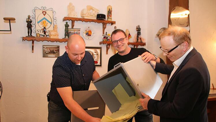 Robert Müller, Jürgen Lieb und Roland Dömling leeren eine Wahlurne in der Zehntscheune aus.  Foto: Thomas Malz