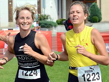 Das Ziel vor Augen und noch genug Kraft für ein Lächeln: Beim 29. Herzoman bogen Daniela Rothe und Janice Plötzner gemeinsam in die letzte Kurve ein schafften es in die Top Ten der Altersklasse W35. Foto: herzopress/Archiv