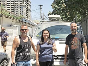 Wolfgang Dusold (l.) und Alexander Brehm mit der Caritas-Büroleiterin Parwina Tadjibaewa vor dem Opel-Bus Foto: p