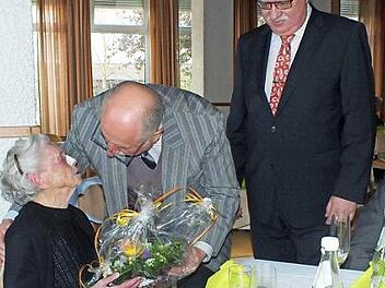 Karlheinz Schneider (Mitte) und Karl-Heinz Bauer überreichen der 106-jährigen Hermine Rauch ein Blumengebinde. Foto: Manfred Welker