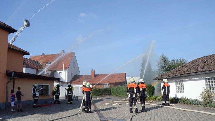 Aus mehreren Strahlrohren, unter anderem auch aus schwindelnder Höhe von der Drehleiter aus, musste ein Brand in einem Restaurant in Knellendorf gelöscht und ein Nachbargebäude geschützt werden. Dies zauberte sogar das Naturschauspiel eines Regenbogens hervor. Foto: Karl-Heinz Hofmann
