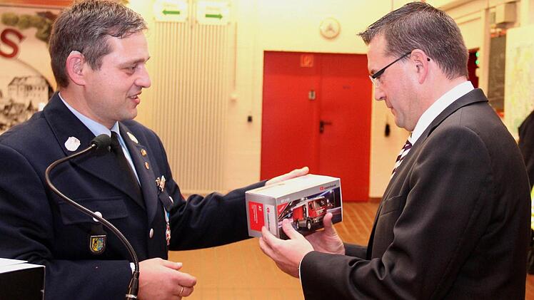 Kommandant Jürgen Hörrlein übergibt Fischkal die "kleine Rosi" für den Schreibtisch.