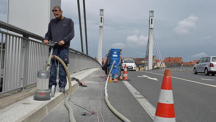 Ein Arbeiter bereitet die Fahrbahnkappen der Löwenbrücke für eine Verstärkung der Betonschicht vor. Foto: Ronald Rinklef
