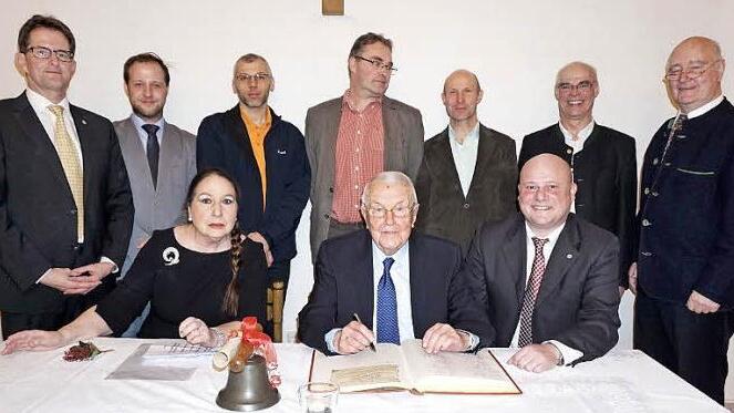 Festakt zur Errichtung der Rudi Jung Stiftung zur Förderung des Kinder- und Jugensports in Bischofsheim und zum Erhalt der Kirchenorgel der Stadtpfarrkirche St. Georg und Übergabe der Ehrenbürgerwürde. Das Bild zeigt Karla und Rudi Jung mit Bürgermeister Georg Seiffert beim Eintrag in das Goldene Buch der Stadt Bischofsheim. Stehend im Bild von links: Peter Suckfüll (stellvertretender Landrat), Michael Beer (RWV Haselbach), Gunnar Schatz (TSV Bischofsheim), Axel Braun (VfR Stadt Bischofsheim)...