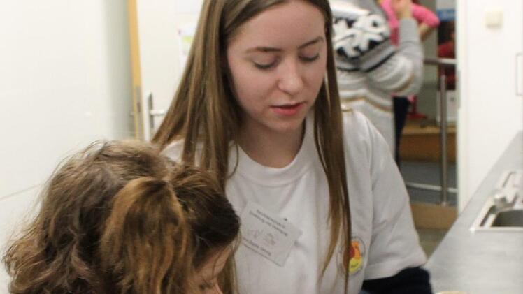 : Ann-Sophie Gehring (rechts) zeigt Lenja Zoesch, wie man den Hefeteig richtig formt.