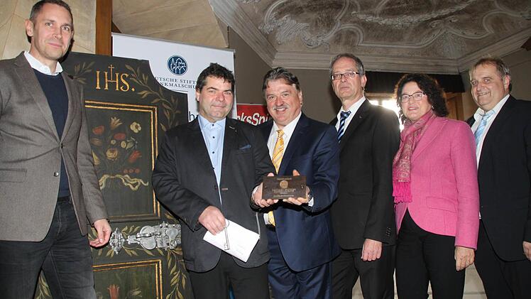Restaurator Uwe Franke übergibt eine Bronzetafel. Von links: Bürgermeister Martin Bernreuther, Uwe Franke, Landrat Klaus Peter Söllner, Uni-Präsident Stefan Leible, Marion Resch-Heckel von der Regierung von Oberfranken sowie Klaus Bodenschlägel von der Stiftung.