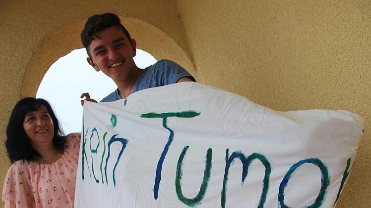 Lebensziel kurz zusammengefasst: Heike Reck und ihr Sohn Mirco halten ein Plakat hoch, das Mircos Schwester anlässlich seiner Konfirmation gemacht hat. "Kein Tumor" ist die Hauptaussage.  Foto: Diana Fuchs