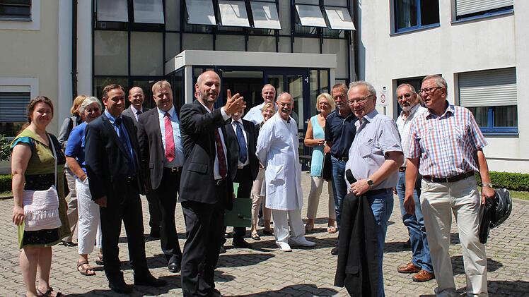 Verwaltungschef Albert Prickarz (vorne links) erläuterte den Ausschussmitgliedern, wo im Hof des Höchstadter Krankenhauses der Anbau stehen soll.  Foto: Andreas Dorsch