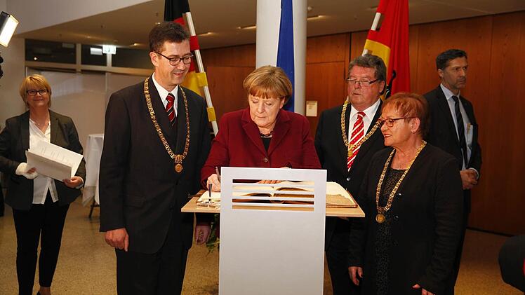 Angela Merkel tr&auml;gt sich in das Goldene Buch der Stadt W&uuml;rzburg ein. Foto: Stadt W&uuml;rzburg