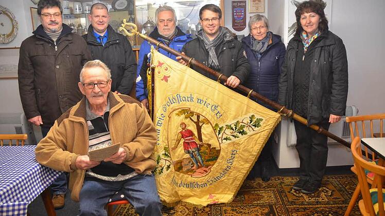Sie geben die Hoffnung nicht auf. Der Vorstand des Gesangvereins "Liederkranz" Gundelsdorf mit einigen Neumitgliedern und ihrer Vereinsfahne aus dem Jahr 1928: Ehrenmitglied Kurt Bausenwein (sitzend) sowie (stehend von links) Werner Reinhardt (Vorsitzender), Marco Wich (Neumitglied und Kassier), Stefan Porzelt (Neumitglied), Sven Schuster (Neumitglied), Elisabeth Reinhardt, Sabine Porzelt (Neumitglied). Foto: Hofmann