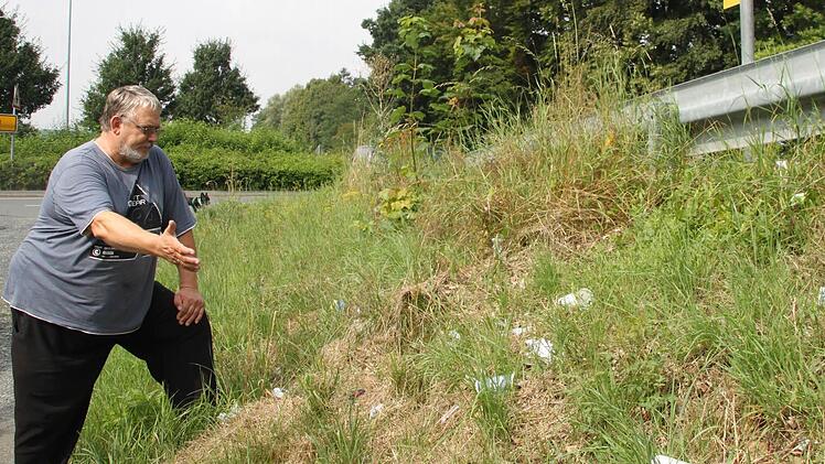 Das regt Imbiss-Betreiber Detlef Hommer auf: der Müll bei der Bushaltestelle neben seinem Maintal-Grill (so sieht die ganze Böschung aus) und das Verhalten der Behörden. Foto: Stephan Tiroch