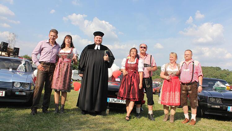 Pfarrer Tobias Knötig traute am Samstag vor den jeweiligen Ford-Capris (von links) Edmund und Regine Hinz, Jutta und Wilfried Rippl sowie Simone-Edith und Guido Schwermer kirchlich. Foto: Carsten Höllein