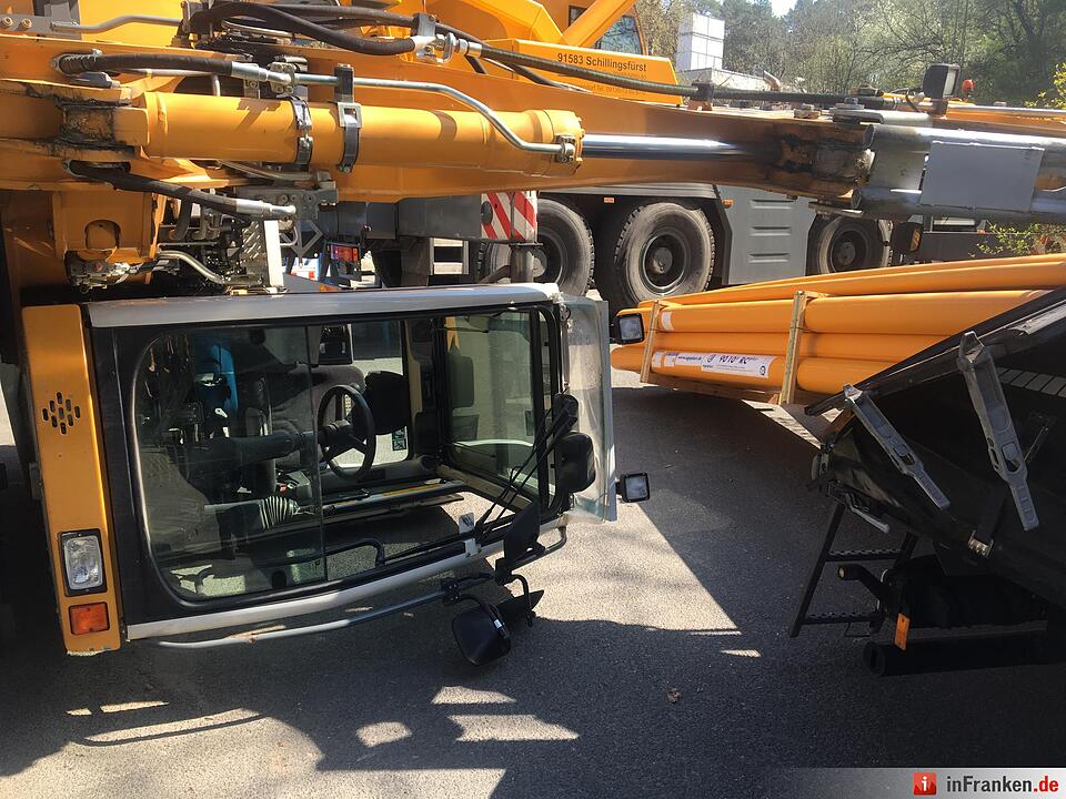 Bagger kippt bei Entladevorgang auf Uni-Baustelle umFahrer wird verletzt ins Krankenhaus gebracht – Bergekran vor Ort