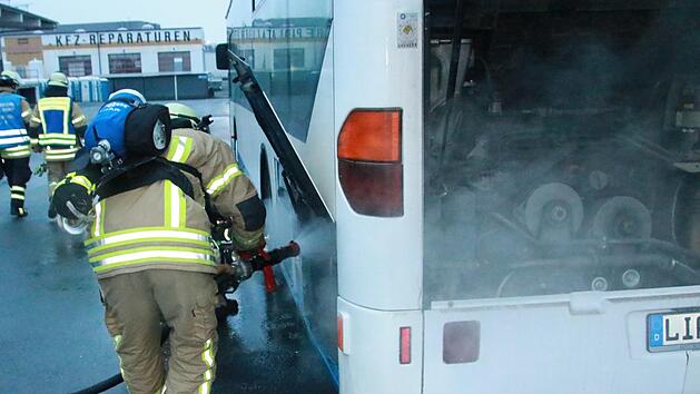 Die Feuerwehrleute beim L&ouml;schen der Flammen im Motorraum des Busses   Foto: Matthias Einwag