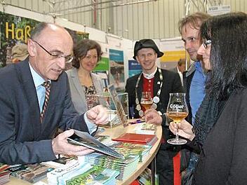 Landrat Wilhelm Schneider, die Gesch&auml;ftsf&uuml;hrerin des Tourismus-Verbandes Ha&szlig;berge, Susanne Volkheimer, und Bierprinz Sebastian Gocker (von links) r&uuml;hrten auf der Freizeitmesse in N&uuml;rnberg die Werbetrommel f&uuml;r Urlaub in den Ha&szlig;bergen.  Foto: Moni G&ouml;hr/Landratsamt Ha&szlig;berge