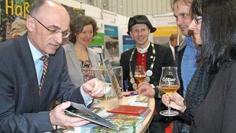 Landrat Wilhelm Schneider, die Gesch&auml;ftsf&uuml;hrerin des Tourismus-Verbandes Ha&szlig;berge, Susanne Volkheimer, und Bierprinz Sebastian Gocker (von links) r&uuml;hrten auf der Freizeitmesse in N&uuml;rnberg die Werbetrommel f&uuml;r Urlaub in den Ha&szlig;bergen.  Foto: Moni G&ouml;hr/Landratsamt Ha&szlig;berge