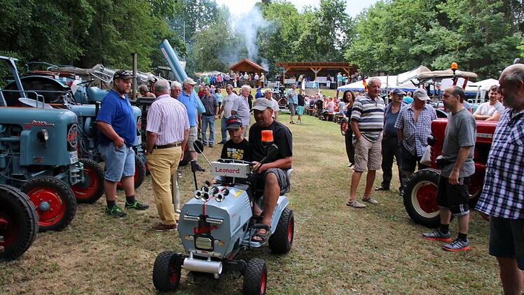 Für seinen Sohn Leonard hat Norbert Hamberger (Ebersdorf) ebenfalls einen Eicher gebaut. Unter all den großen Fahrzeugen zogen die beiden auf dem ehemaligen Rasenmäher am Sonntag beim 19. Eichertreffen in Krumbach viele Blicke auf sich. Foto: Bettina Knauth