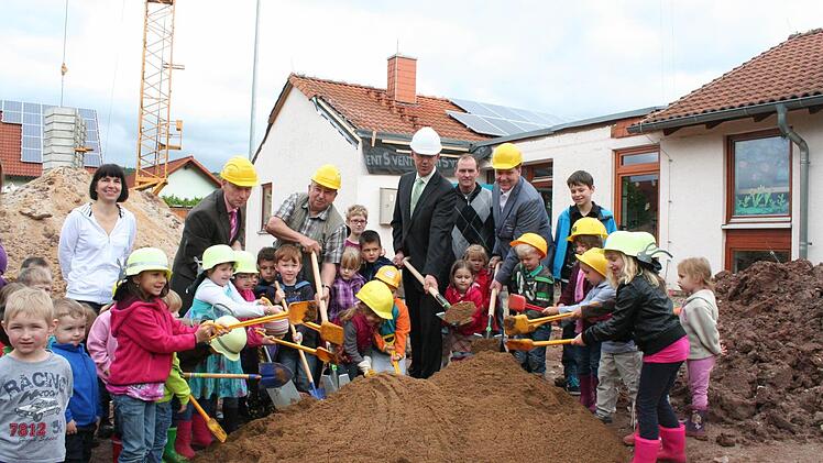 Die "Wackelzähne" machten zusammen mit dem Architekten Heinz Oppelt, Kirchenpfleger Michael Reul, Bürgermeister Jakobus Kötzner und dem Pfarrgemeinderatsvorsitzenden Jörg Hofmann (mit Helm von links) den Spatenstich. Der Neubau soll an den Kindergarten (im Hintergrund) "angedockt" werden.  Foto: Evi Seeger