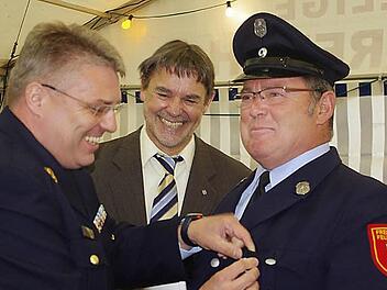 Kreisbrandinspektor Matthias Schuhbäck und stellvertretender Landrat Gerhard Wunder zeichnen Matthias Ebert (von links) mit dem staatlichen Ehrenzeichen in Silber aus. Foto: Heike Schülein