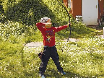 Ein Kind beim therapeutischen Bogenschießen