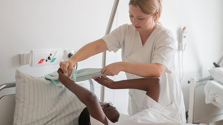 Eine Pflegekraft pflegt eine Patientin.
