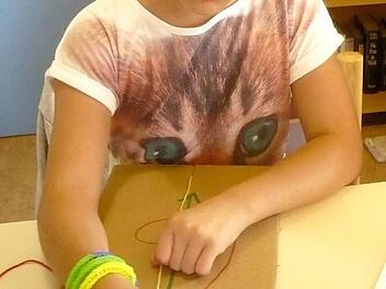 Klara flicht eifrig an ihrem Makrameebändchen. Foto: Johanna Blum