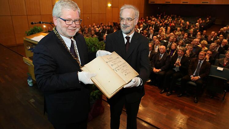 Werner Taegert (rechts) überreichte dem Universitätspräsidenten Godehard Ruppert  alte Matrikelbände der Universität Bamberg. Foto: Barbara Herbst