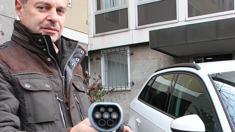Alfred Gerlach, verantwortlich für den Fuhrpark am Landratsamt, betankt ein neues Hybrid-Dienstfahrzeug mit Strom.  Foto: Benedikt Borst