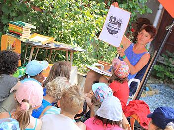 Judith Allert bei der Lesung für Kinder in ihrem Bauernhof in Püchitz. Wie in ihren Büchern illustriert sie die Texte auch bei der Lesung mit Zeichnungen, was alles noch kurzweiliger für ihr Publikum werden lässt. Foto: Matthias Einwag