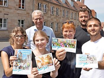 Die Ferienmacher präsentieren vor dem Generationenzentrum in der Erlanger Straße, dem früheren Freizeitheim, die vier Hefte: Evi Bauer, Simone Voit, Bea Wirth und Daniel Birk (vorne von links) mit German Hacker und Thomas Schönfelder (hinten) Foto: Bernhard Panzer