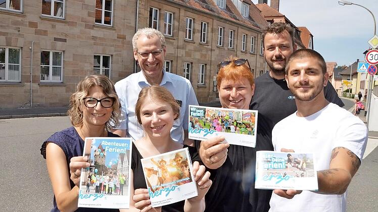 Die Ferienmacher präsentieren vor dem Generationenzentrum in der Erlanger Straße, dem früheren Freizeitheim, die vier Hefte: Evi Bauer, Simone Voit, Bea Wirth und Daniel Birk (vorne von links) mit German Hacker und Thomas Schönfelder (hinten) Foto: Bernhard Panzer
