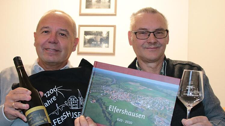Chronik, Wein, Tasche oder Glas: Jürgen Englert und Rainer Kuhn zeigen die Geschenkideen rund ums Jubiläum. Foto: Ralf Ruppert
