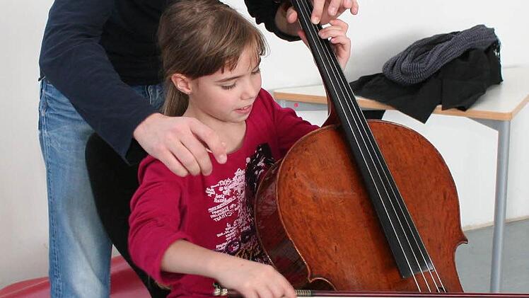 Die neunjährige Alisha aus Oberndorf würde gerne Cello lernen. Unter Anleitung von Maximilian Hornung durfte sie ein paar Töne auf dem wertvollen Instrument spielen.