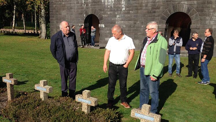 Bei der Übergabe von Gruppe 1 an Gruppe 2: Edgar Schlembach und Anton Ziegler (vorne von links) zeigen Norbert Ziegler die Anlage. Im Hintergrund die Krypta des Friedhofes mit der Gedenkstätte. Foto: Paul Ziegler
