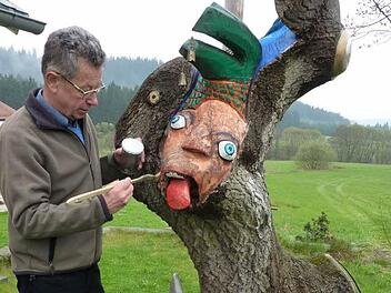Eine Attraktion ist der "Narrenbaum" aus Eschenholz. Gottfried Grau legt letzte Hand an an seinem Kunstwerk.  Foto: Gerd Fleischmann