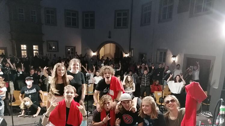 Rockfan Leni (oben, 2. von links) hat alles   inszeniert. Vor ihr posen alle Künstler des Abends gemeinsam auf der Bühne.