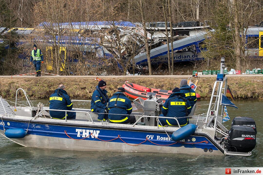 Ein Boot des THW fährt am 10.02.2016 bei Bad Aibling (Bayern) an der Unglücksstelle vorbei. Dort hat die Bergung der beiden verunglückten Züge begonnen. Die ineinander verkeilten Züge sollen getrennt und dann in Teilen geborgen werden. Bei dem schweren Zugunglück in Oberbayern waren am Dienstag zehn Menschen ums Leben gekommen, Dutzende wurden verletzt. Foto: Peter Kneffel/dpa